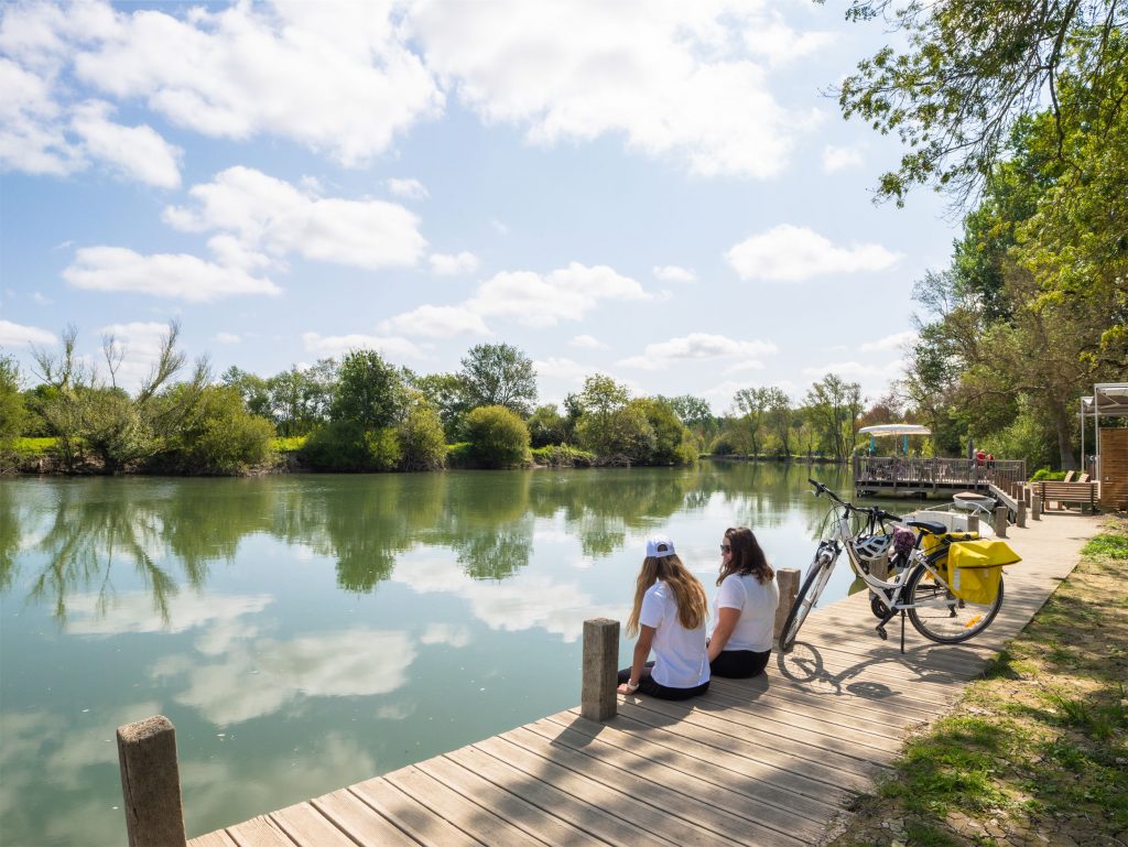 2 cyclistes assises en bord de Charente à côté de leurs vélos