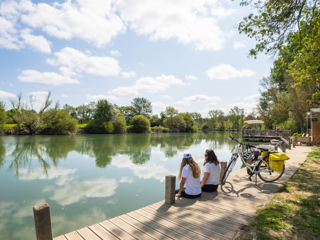 2 cyclistes assises en bord de Charente à côté de leurs vélos