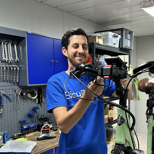 Adrien in a blue BicyBAGS t-shirt repairing a bicycle