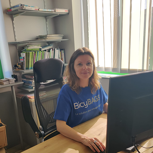 Lucie en tshirt bleu assise à son bureau